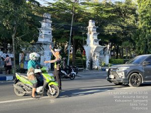 Hadirkan Kamseltibcar Lantas, Personel Satlantas Polres Sampang Seberangkan Pengguna Jalan